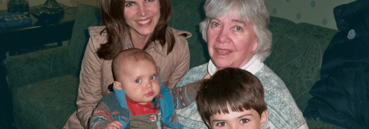 Journalist Natalie Morales sits on a green couch with her mother-in-law and Natalie's two children when they were still young. One is a baby and another is about 6.