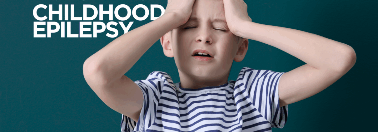 A young white boy around age 8 has his eyes closed and hands on the front of his head as if in pain or frustration. The image has the words "Developments in Childhood Epilepsy" on it.