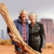 Jim and Geri Taylor stand in the desert in the U.S. West and pose and smile for the camera.